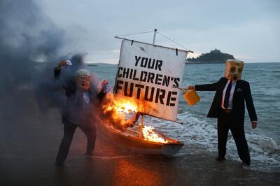 Activists from climate action group Ocean Rebellion set a boat on fire during a demonstration at sunrise at Marazion Beach, Cornwall, Britain, June 5, 2021, ahead of the G7 summit in Carbis Bay, Cornwall. REUTERS/Tom Nicholson