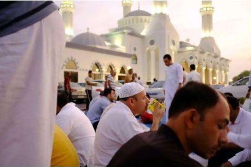 Reaching out: worshippers enjoy the Iftar meal outside the Al Farooq Umar ibn Khattab Mosque in Umm Suqeim.