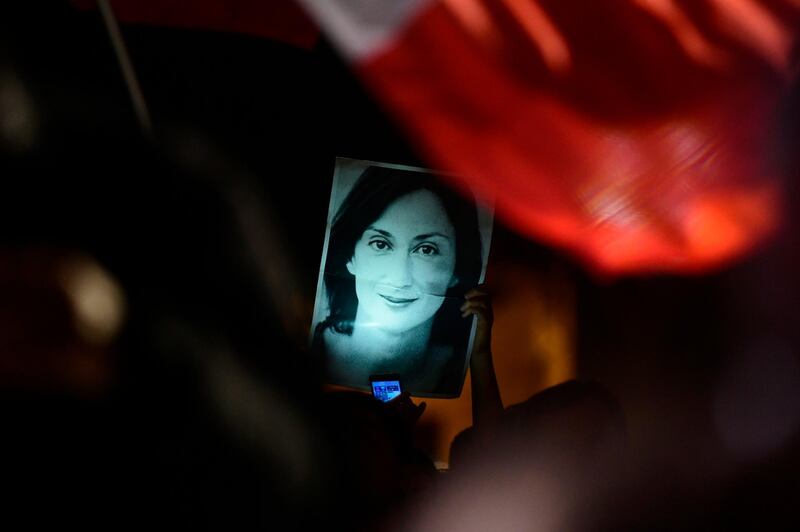 A protester holds up a picture of murdered reporter Daphne Caruana Galizia on the fourth day of a demonstration outside Malta's prime minister's office in Valletta, Malta. AP Photo