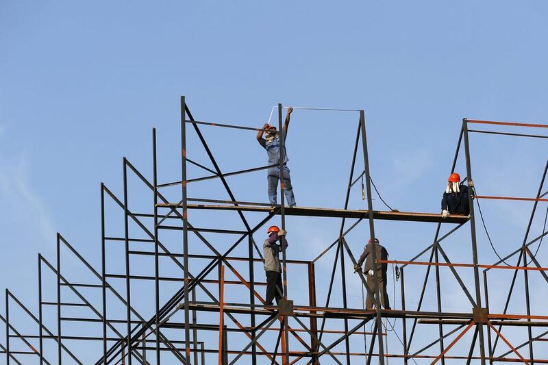 Labourers work on scaffolding at a construction site in Shanghai. China’s economy grew slightly faster than expected in the second quarter as a burst of government stimulus paid dividends. Aly Song / Reuters
