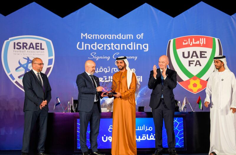 Israeli Football Association (IFA) president Oren Hasson, second left, receives a gift from UAE Football Association President Sheikh Rashid bin Humaid, during the signing of a memorandum of understanding between the two associations in Dubai.  AFP