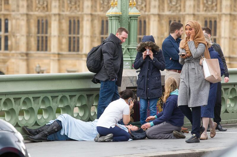 Mandatory Credit: Photo by REX/Shutterstock (8550198aq)
Sequence frame showing a woman visibly distressed passing the scene of the terrorist incident on Westminster Bridge, London.
Pictured: Medics and passers by treat a victim on Westminster Bridge, London
Major incident at Westminster, London, UK - 22 Mar 2017