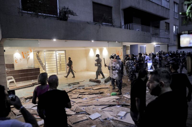 Demonstrators stand before Lebanese security forces after protesters and families of the Beirut blast victims broke into the residence of Lebanon's interior minister in the Qoraitem neighbourhood of western Beirut.