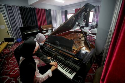 Music teacher Yulia Abu Namous trains a Palestinian student on the piano at the Edward Said National Conservatory of Music in Gaza on September 14, 2021. Mustafa Mohamad for The National
