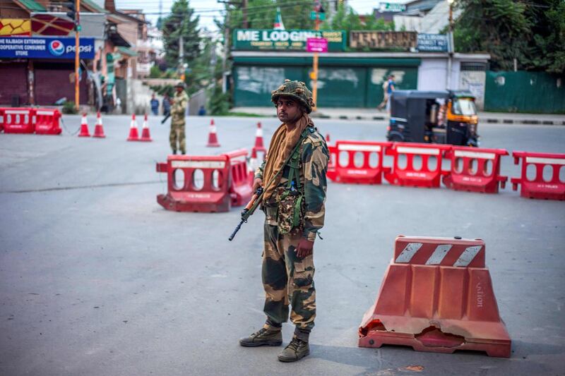 Security personnel stand guard on a street in Srinagar. AFP