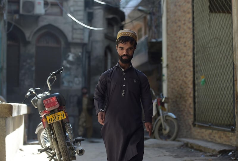 Rozi Khan, 25, walks on a street in Rawalpindi. AFP