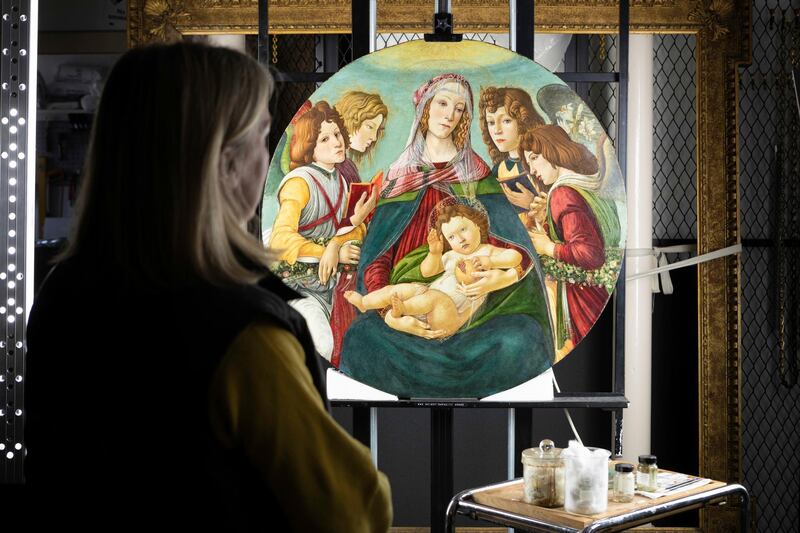 In this painting made available by English Heritage on Thursday March 28, 2019, English Heritage Conservator Rachel Turnbull completes the conservation of "Madonna of the Pomegranate", a painting revealed as a rare example by the workshop of Botticelli. After stripping back a century of yellowing varnish and surface dirt, the painting thought to be a fake Sandro Botticelli, in fact came from the masterâ€™s own Florence workshop. (Christopher Ison/English Heritage via AP)