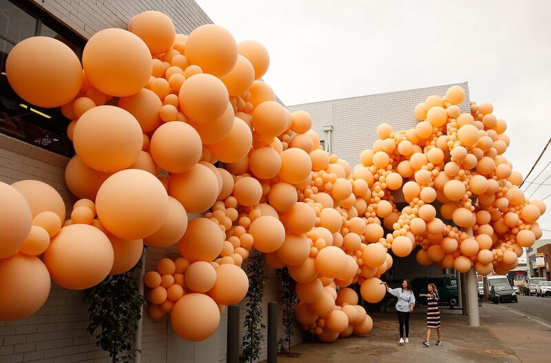 People walk past an installation by renowned LA-based balloon designer Jihan Zencirli, aka Geronimo in Melbourne, Australia. The installation is Zencirli's first ever public Australian creation, using 5000 balloons to cover the 39m facade and will open Melbourne Design Week 2018. Scott Barbour / Getty Images