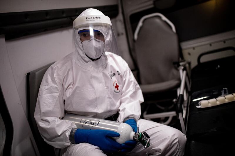 Jounieh, Lebanon. A Lebanese Red Cross volunteer paramedic holds an oxygen canister in the back of an ambulance during a callout to a patient with Coronavirus on a night shift in the Jounieh region. Today Lebanon registered 4176 new Coronavirus cases, and 52 deaths. Tom Nicholson for The National