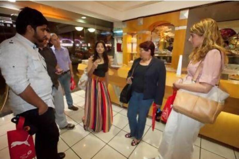 Arva Ahmed, centre, with one of her walking food tour groups at Samadi Sweets in Deira. Jaime Puebla / The National