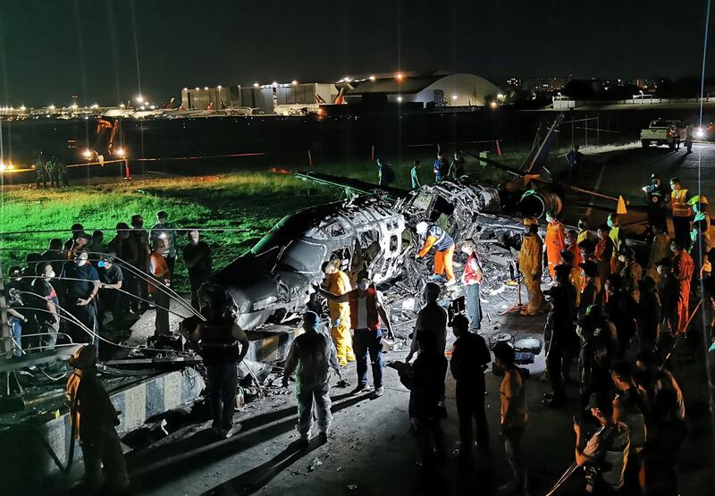 Investigators gather around  burnt Lion Air plane at Manila's International Airport, in Manila, Philippines.  EPA