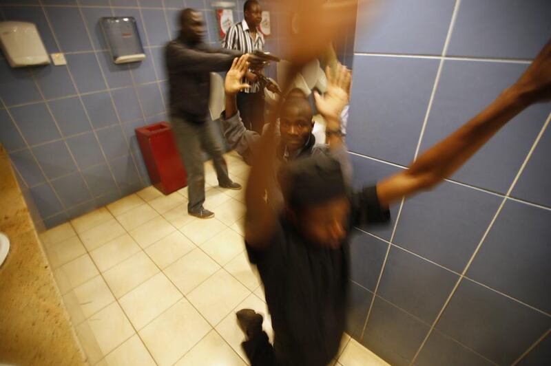 Police search people in a bathroom during the attack. The gunmen carried AK-47s and wore vests with hand grenades on them, said Manish Turohit, 18, who hid in a parking garage for two hours. “They just came in and threw a grenade. We were running and they opened fire.” Goran Tomasevic / Reuters