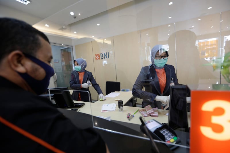 A Bank Negara Indonesia teller serves a customer in Banda Aceh, Indonesia.  EPA