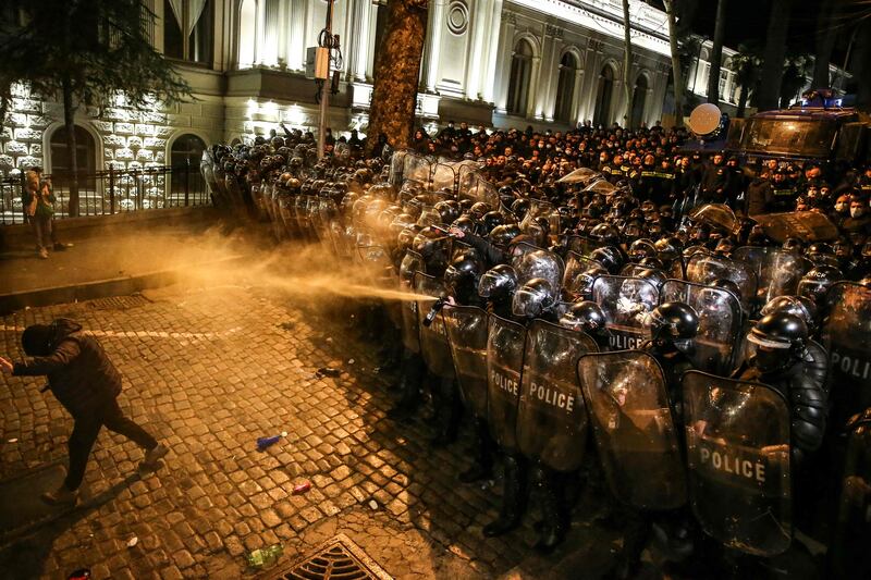 Riot police spray tear gas at protesters during clashes near the Georgian parliament in Tbilisi. AFP