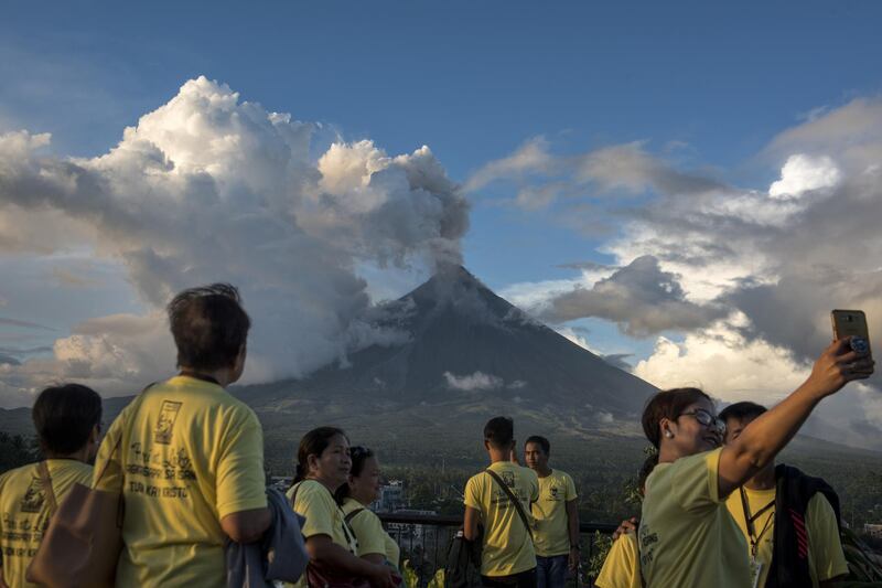 Visitors and residents flock to a viewing area to see the Mayon volcano as it erupts. Jes Aznar / Getty Images