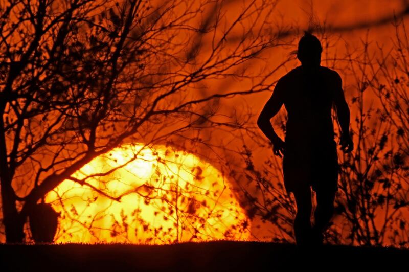 A man runs in a park as the sun sets, in Kansas City. AP Photo