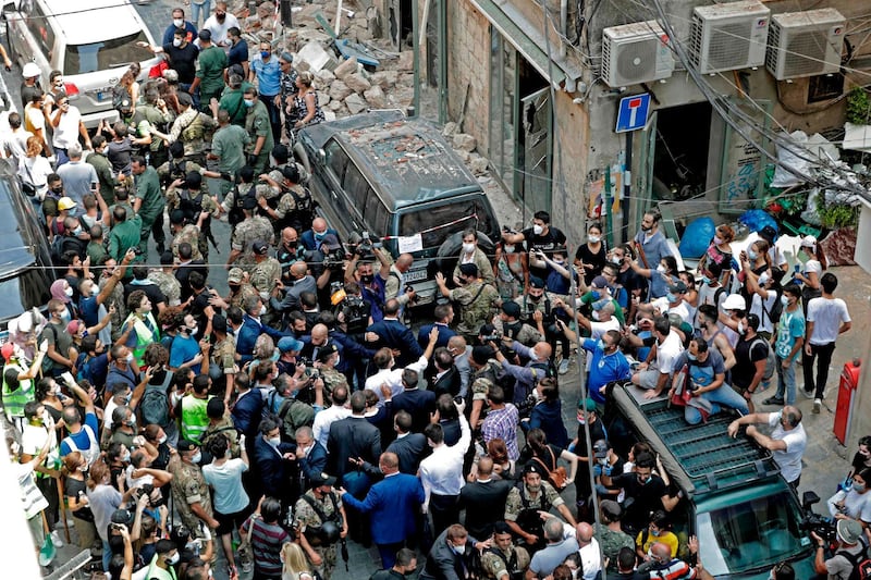 French President Emmanuel Macron greets people during a visit to the Gemmayzeh neighbourhood, which has suffered extensive damage due to a massive explosion in the Lebanese capital, on August 6, 2020. French President Emmanuel Macron visited shell-shocked Beirut, pledging support and urging change after a massive explosion devastated the Lebanese capital in a disaster that has sparked grief and fury. / AFP / ANWAR AMRO
