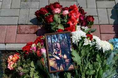 Flowers surround a photo of Oleh Panchenko next to his grave during his burial service in Pokrovsk, Donetsk region, eastern Ukraine, Thursday, Aug.  4, 2022.  Panchenko, 48, a Ukrainian soldier, was killed in battle with Russian forces July 27 in the Donetsk region.  (AP Photo / David Goldman)