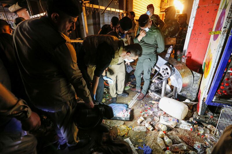 Iraqi security forces inspect the site of an explosion in the Sadr City district of Baghdad.