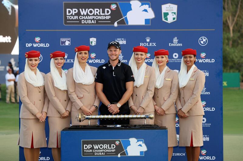Danny Willett of England poses with the DP World Tour trophy with the Emirates cabin crew following the final round of the DP World Tour Championship at Jumeirah Golf Estates in Dubai, United Arab Emirates. Getty Images