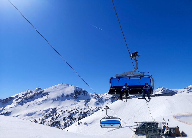 Winter sports enthousiasts take a ski lift in the Obertauern ski resort in the Salzburg region, Austria, on March 31, 2021, amid the novel coronavirus / COVID-19 pandemic. (Photo by BARBARA GINDL / APA / AFP) / Austria OUT