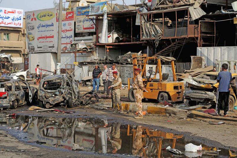 Security forces inspect the site of a car bomb explosion in the largely Shiite neighbourhood of Talibiyah in Baghdad. Khalid Mohammed / AP Photo / October 16, 2014