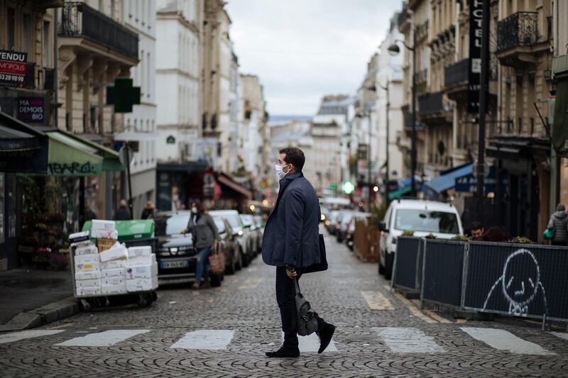 A man wearing a mask walks in the Montmartre district of Paris. AP Photo