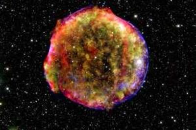 This composite image provided by NASA Wednesday Dec. 3, 2008 of the Tycho supernova remnant combines infrared and X-ray observations obtained with NASA's Spitzer and Chandra space observatories, respectively, and the Calar Alto observatory, in Spain. The image shows the remnant of a supernova that was observed in 1572 by Danish astronomer Tycho Brahe. The explosion has left a blazing hot cloud of expanding debris (green and yellow). The location of the blast's outer shock wave can be seen as a blue sphere of ultra-energetic electrons. Newly synthesized dust in the ejected material and heated pre-existing dust from the area around the supernova radiate at infrared wavelengths of 24 microns (red). Foreground and background stars in the image are white. (AP Photo/NASA)