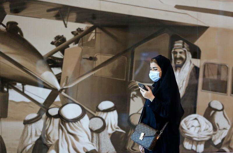 A passenger walks past an image of the late King Abdulaziz Al Saud at King Abdulaziz International Airport in Jeddah, Saudi Arabia, after authorities lifted a ban on international travel. AP Photo