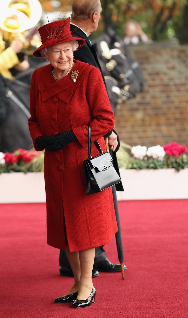 Queen Elizabeth II, wearing red, arrives to welcome Qatar's Sheikh Hamad bin Khalifa Al Thani to her Windsor residence on October 26, 2010. Getty Images