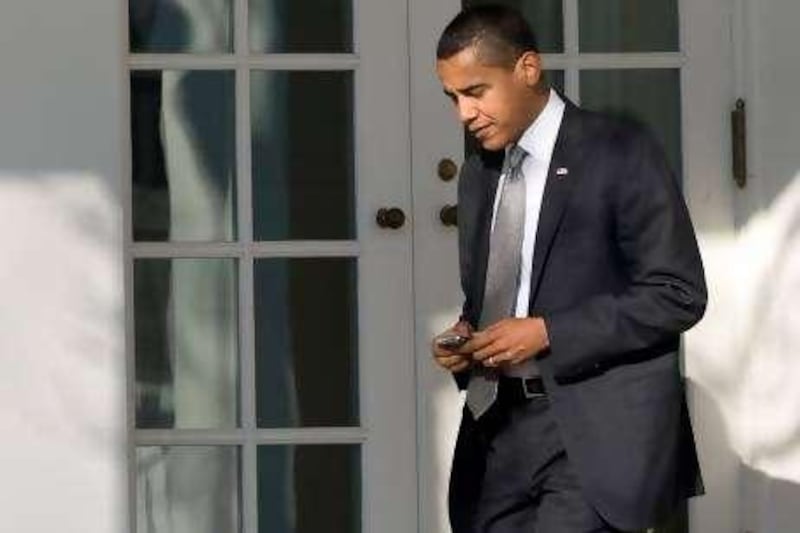 US President Barack Obama uses his BlackBerry or similar device as he walks to the Oval Office after returning to the White House in Washington, DC, January 29, 2009, after attending a performance at his daughter's school. AFP PHOTO / Saul LOEB