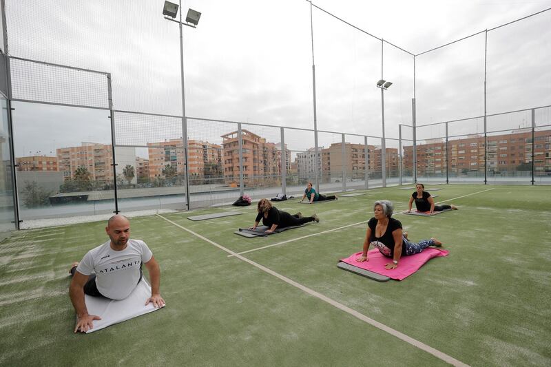 Several people practice yoga at a outdoor sport complex in Valencia, eastern Spain. Valencia's regional authorities have eased restrictions, allowing outdoor sports without physical contact and a maximum of four people. EPA