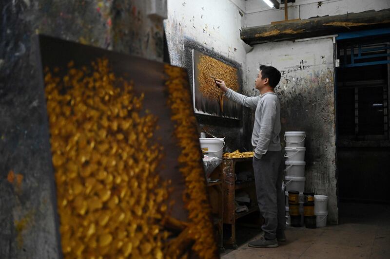 An artist paints in a workshop in the Dafen Village, Guangdong province, China. All Photos: AFP