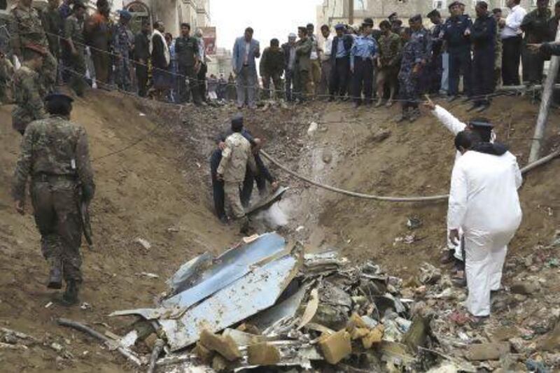 Air force officers and police investigate the site of a military plane crash in Yemen's capital Sanaa today. Khaled Abdullah / Reuters