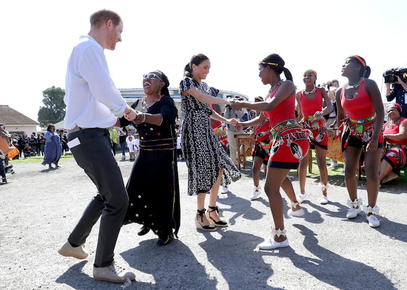 Prince Harry, Duke of Sussex and Meghan, Duchess of Sussex, dance as they visit a Justice Desk initiative in Nyanga township, during their royal tour of South Africa on September 23, 2019 in Cape Town, South Africa. Getty Images