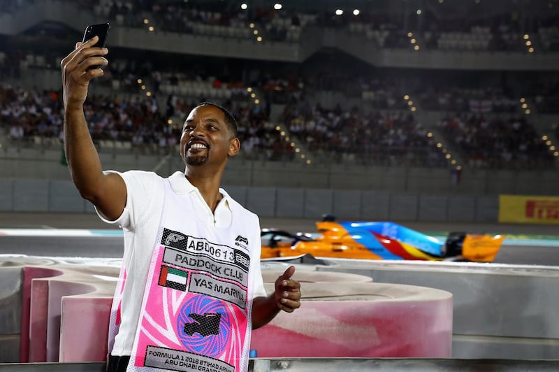 Actor Will Smith takes a selfie as Fernando Alonso drives past. Getty Images