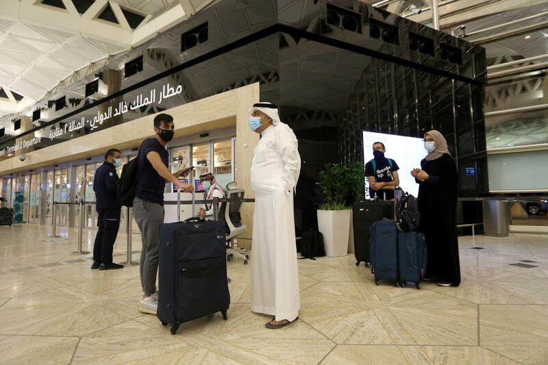 Travellers maintain social distancing as they wait to check-in their baggage at the King Khalid International Airport in Riyadh, Saudi Arabia. Reuters