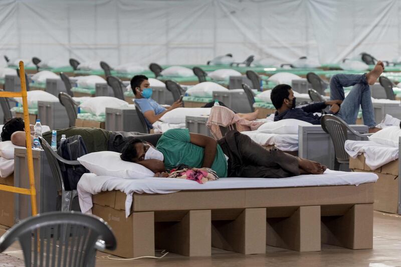 Patients rest laying on beds made out of cardboard inside the campus hall of spiritual organisation Radha Soami Satsang Beas (RSSB), converted into a COVID-19 coronavirus care centre, in New Delhi.  AFP