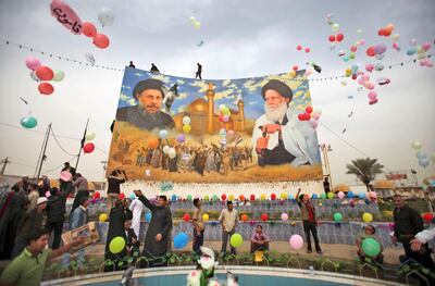 Shiite Muslims gather in Al-Sadreen Square, next to a mural showing the late Grand Ayatollah Mohammed Baqir al-Sadr, left, and the late Grand Ayatollah Mohammed Sadeq al-Sadr, right, after Friday prayers in Sadr City in Baghdad, Iraq, Friday, March 5, 2010. Iraqis are due to go to the polls Sunday, March 7, 2010 for Iraq's parliamentary elections. (AP Photo/Karim Kadim)