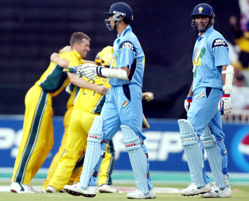 Indian batsmen Zaheer Khan (R) and Ashish Nehra (2/R) trudge of as the AUstralia players celebrate after Australia won the final of the ICC Cricket World Cup played at the Wanderers Stadium in Johannesburg 23 March 2003.  Batting first, Australia scored 359-2 from their 50 overs, their highest ever one-day total and then dismissed India for 234 to win by 125 runs.  AFP PHOTO/William WEST (Photo by WILLIAM WEST / AFP)