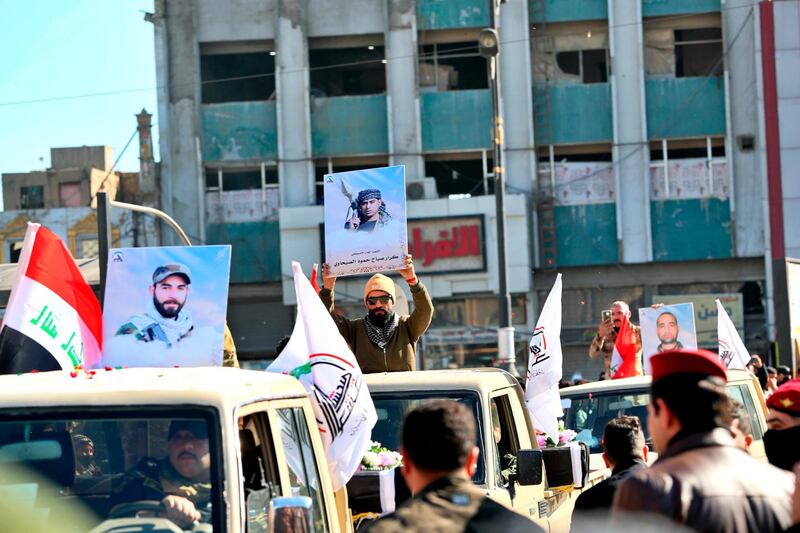 Popular Mobilisation Forces march with posters and symbolic coffins of their killed fighters in Tahrir Square, Baghdad, Iraq, Saturday, Dec. 26, 2020. (AP Photo/Khalid Mohammed)