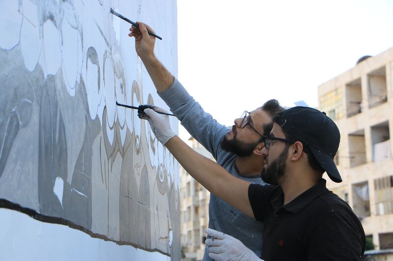 Al Shami and his friend finish the mural. Photo supplied by Abu Malek Al-Shami