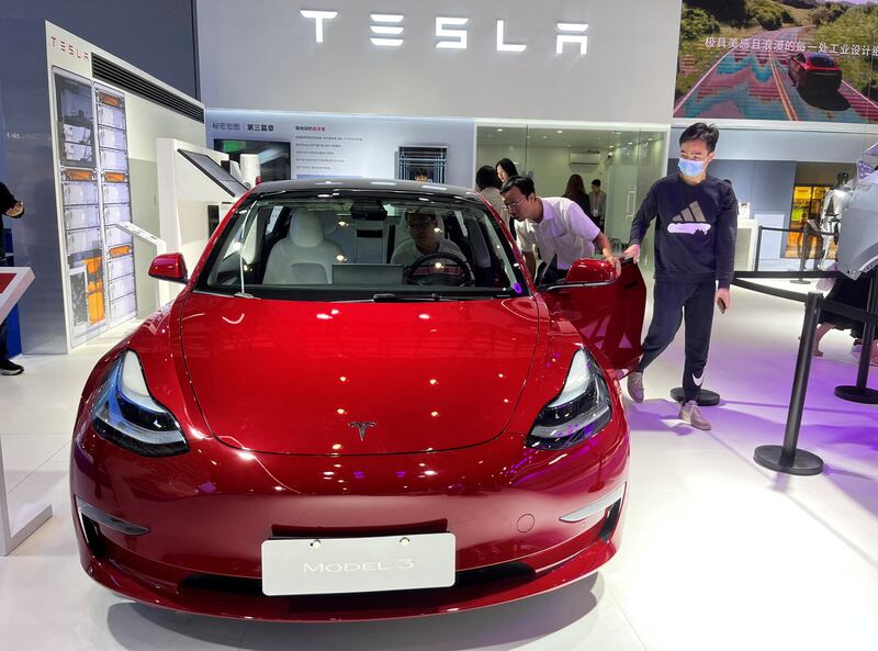 Visitors look at a Tesla Model 3 EV at the third China International Consumer Products Expo, in Haikou, China. For 2023, Tesla aims to produce about 1.8 million cars. Reuters
