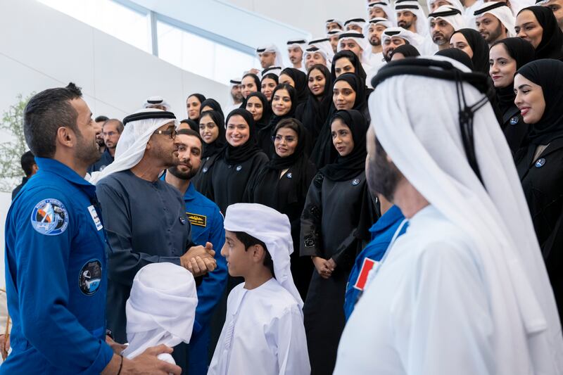 President Sheikh Mohamed speaks with employees of the Mohammed bin Rashid Space Centre during a homecoming reception for UAE astronaut Sultan Al Neyadi, left, at the new Abu Dhabi International Airport terminal. Photo: UAE Presidential Court