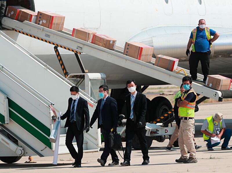 Chinese embassy officials attend the arrival of medical aid at Baghdad Airport in Iraq. Medical aid from the People's Republic of China arrived in Baghdad on Monday to help Iraq curb the spread of the coronavirus. AP