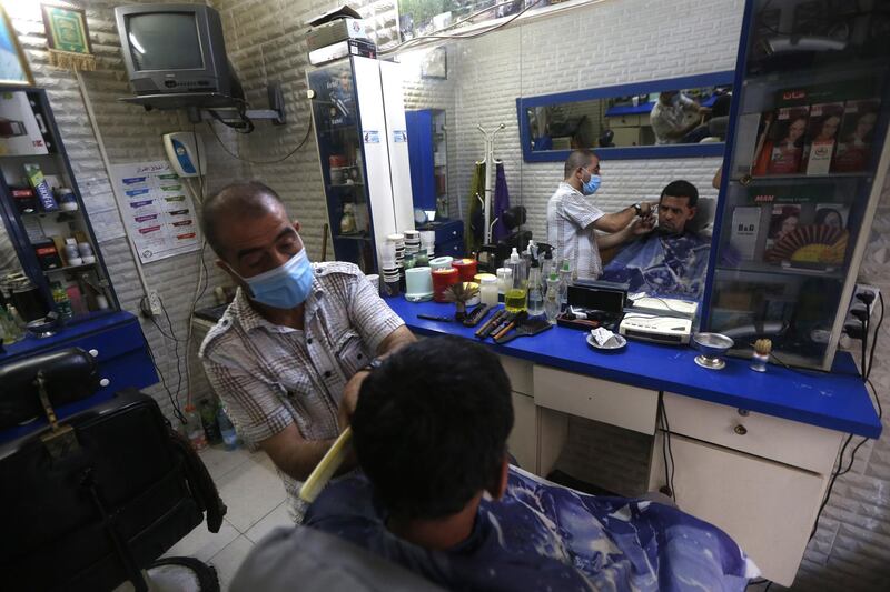A Palestinian barber gives a customer a haircut ahead of the Eid Al Adha festival, in the West Bank city of Nablus. EPA