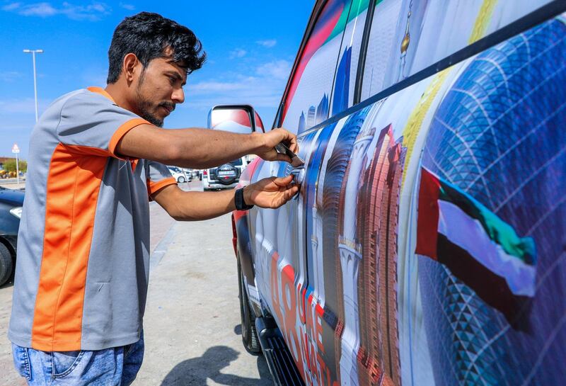 Abu Dhabi, United Arab Emirates, November 25, 2019.  
  Auto accessory and detailing shops at Musaffah M-2 area who decorate cars for  UAE National Day.
Target Care Care full body wraps a car with the UAE National Day theme starting at AED 2K.  It takes four hours labor done by a 4 man team.
Victor Besa / The National
Section:  NA
Reporter: