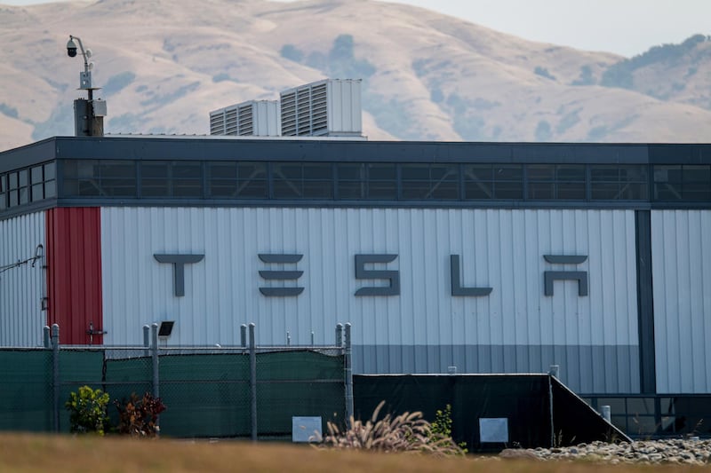 Signage is displayed at the Tesla Inc. assembly plant in Fremont, California, U.S., on Thursday, Aug. 13, 2020. Tesla shares jumped the most in a month after the electric-car maker said it would split its stock, making it more accessible to individual investors, with further boost from reports that said the company has set up an insurance brokerage in China. Photographer: David Paul Morris/Bloomberg