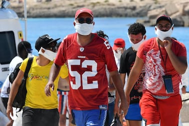 Migrants from Tunisia disembark from an Italian Coast Guard on the island of Lampedusa on July 30, 2020. AFP