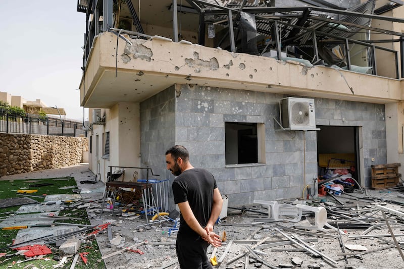 Across the border in Israel, an Israeli man checks a house that was hit by a Hezbollah rocket in Kiryat Shmona in northern Israel near the Lebanon border. AFP